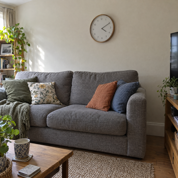 Round wall clock above a sofa