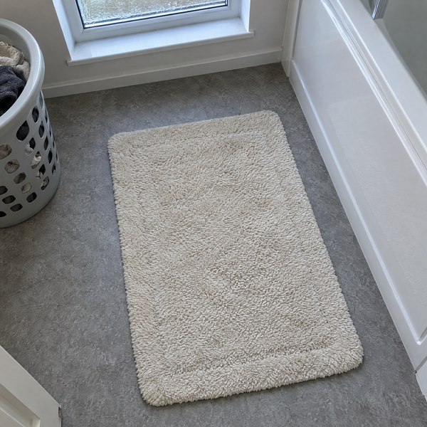 Cream bath mat on a bathroom floor